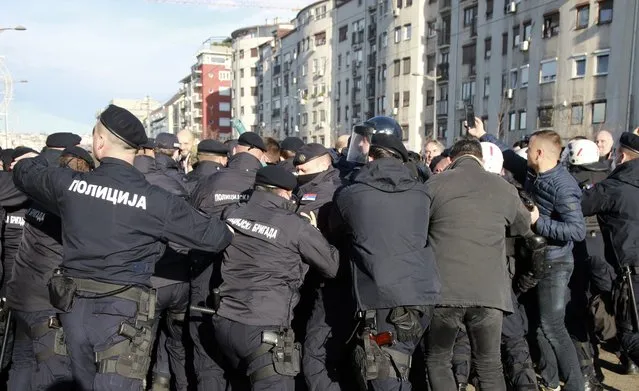 Serbian police officers and protesters clash during a protest in Belgrade, Serbia, Saturday, November 27, 2021. Skirmishes on Saturday erupted in Serbia between police and anti-government demonstrators who blocked roads and bridges in the Balkan country in protest against new laws they say favor interests of foreign investors devastating the environment. (Photo by Milos Miskov/AP Photo)
