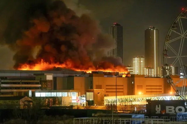 A massive blaze is seen over the Crocus City Hall on the western edge of Moscow, Russia, Friday, March 22, 2024. Several gunmen have burst into a big concert hall in Moscow and fired automatic weapons at the crowd, injuring an unspecified number of people and setting a massive blaze in an apparent terror attack days after President Vladimir Putin cemented his grip on the country in a highly orchestrated electoral landslide. (Photo by Sergei Vedyashkin/Moscow News Agency via AP Photo)
