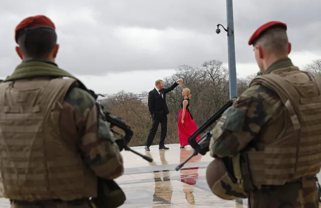 French army paratroopers look at a couple dancing as they patrol at Trocadero square in Paris, France, March 30, 2016 as France has decided to deploy 1,600 additional police officers to bolster security at its borders and on public transport following the deadly blasts in Brussels. (Photo by Philippe Wojazer/Reuters)