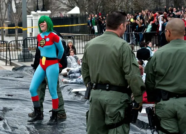 A protestor is arrested as students demonstrate against the proposed Keystone XL pipeline in front of the White House in Washington, DC on March 2, 2014. Students from around the country gathered to oppose the tar sands oil pipeline from Canada, which they say is dangerous for the environment. (Photo by Nicholas Kamm/AFP Photo)