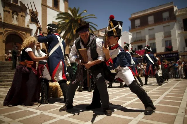 Members of historical battle re-enactment groups, dressed as bandits and the French army (R), participate in a Spanish Independence War battle re-enactment during the third edition of “Ronda Romantica” (Romantic Ronda) in Ronda, southern Spain, May 16, 2015. (Photo by Jon Nazca/Reuters)