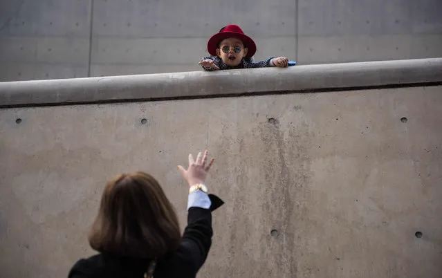 A child gestures to a woman at Dongdaemun Design Plaza, the venue for Seoul fashion week, on March 22, 2016. (Photo by Ed Jones/AFP Photo)