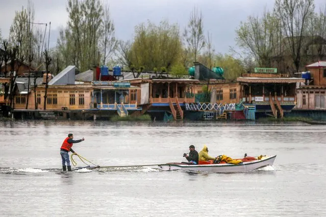 A tourist water-skis across the Dal Lake during rainfall in Srinagar, the summer capital of Indian Kashmir, 29 March 2024. Jammu and Kashmir Disaster Management Authority (JKDMA) on 29 March issued a medium-danger level avalanche warning for four districts of Kashmir division, likely to occur above 2400 meters over Kupwara, Bandipora, Baramulla and Ganderbal districts in next 24 hours, according to a JKDMA spokesperson. (Photo by Farooq Khan/EPA/EFE)