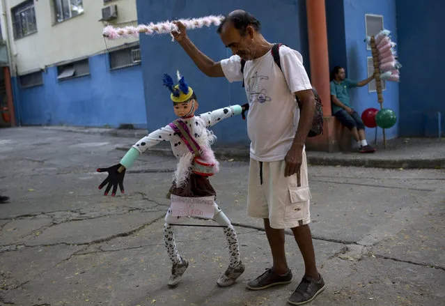 Arlindo, a patient from the Nise da Silveira Mental Health Institute, makes his marionette dance during a carnival parade coined, in Portuguese: “Loucura Suburbana”, or Suburban Madness, in the streets of Rio de Janeiro, Brazil, Thursday, February 23, 2017. (Photo by Silvia Izquierdo/AP Photo)