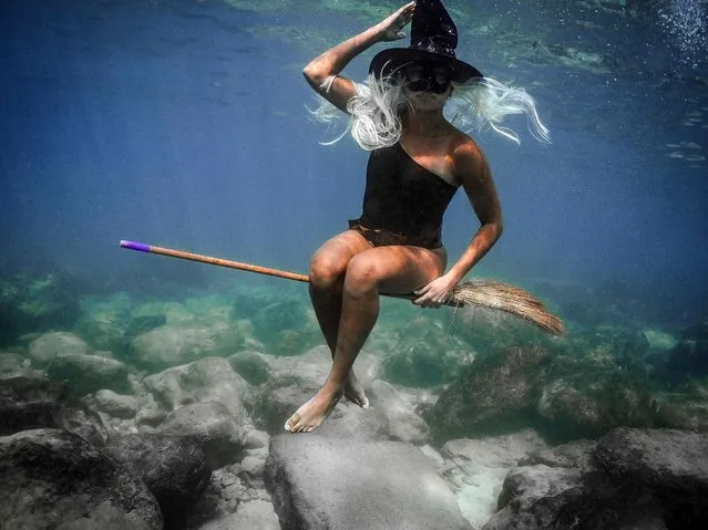 A person dressed in a Halloween costume swims along the coast of the northern Lebanese city of Batroun in northern Lebanon, on October 28, 2021. (Photo by Ibrahim Chalhoub/AFP Photo)