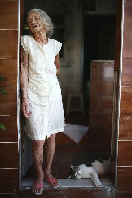 80-year-old Maria de Lourdes de Lima, a 40-year Mare resident, stands in her doorway. (Photo by Mario Tama/Getty Images)