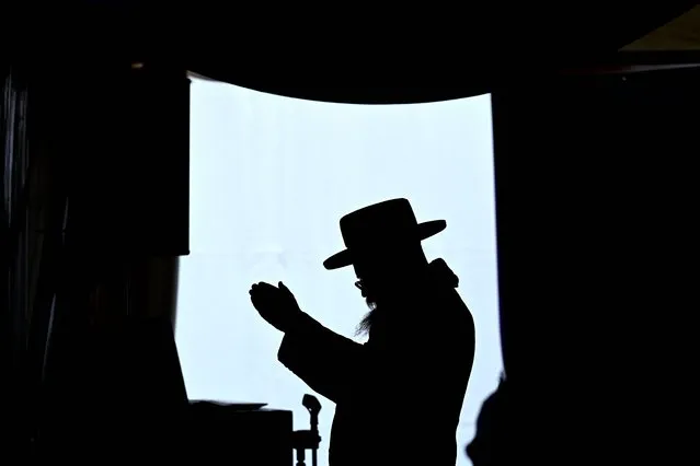 A Hasidic Jewish pilgrim prays at the Jewish cemetery in the town of Lezajsk, Subcarpathian region, southeastern Poland, on March 31, 2024, marking the 237th anniversary of the death of their 18th century spiritual leader, or tzaddik, Rabbi Elimelech Weisblum. Weisblum was one of the founders of the Hasidic movement, whose aim was to revive Judaism in the 18th century. He gained a reputation as a healer of souls and bodies. Those coming to Lezajsk, mostly from Israel, Europe, the United States and Canada, believe that the tzaddik comes down from heaven on the anniversary of his death and takes their requests to God. (Photo by Sergei Gapon/AFP Photo)