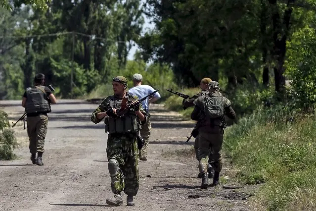 Members of the Ukrainian armed forces patrol an area in the town of Maryinka, eastern Ukraine, June 5, 2015. Ukraine's president told his military on Thursday to prepare for a possible "full-scale invasion" by Russia all along their joint border, a day after the worst fighting with Russian-backed separatists in months.  REUTERS/Gleb Garanich