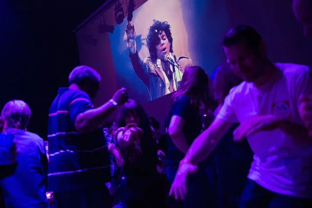 Guests dance to Prince music as a slide show flashes images of the artist above the stage during a memorial dance party at the First Avenue nightclub on April 21, 2016 in Minneapolis, Minnesota. Prince, 57, was pronounced dead shortly after being found unresponsive at Paisley Park Studios in Chanhassen, Minnesota near Minneapolis. (Photo by Scott Olson/Getty Images)