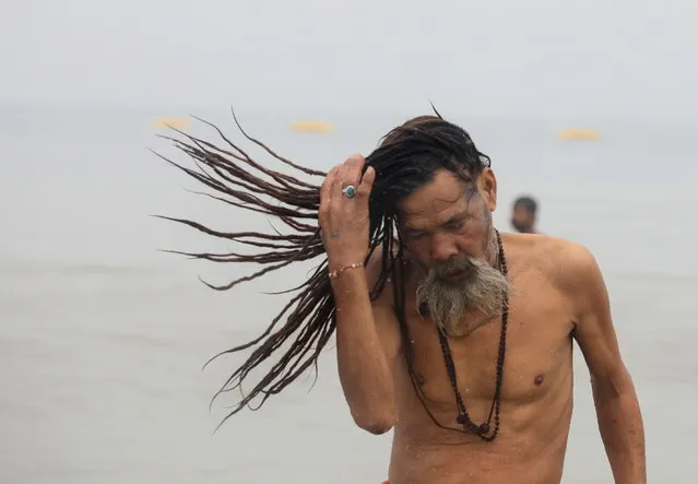 An Indian monk takes a holy dip at Sagar Island during second day of annual fair amid Covid crisis, 130km south of Kolkata, Eastern India, 14 January 2022. Bengal government announced a new partial lockdown and night curfew for fifteen days to combat new Omicron variant. Ganga Sagar Fair is an annual gathering of Hindu pilgrims during Makar Sankranti on Sagar Island, to take a dip in the sacred waters of the Ganges River before it reaches the Bay of Bengal. (Photo by Piyal Adhikary/EPA/EFE)