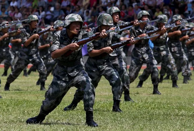 People's Liberation Army (PLA) soldiers show off during a demonstration to the public, at a PLA naval base in Hong Kong, China July 1, 2015. (Photo by Bobby Yip/Reuters)