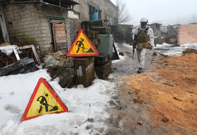 A service member of the Ukrainian armed forces walks at combat positions near the line of separation from Russian-backed rebels outside the town of Avdiivka in the Donetsk Region, Ukraine on February 11, 2022. (Photo by Oleksandr Klymenko/Reuters)