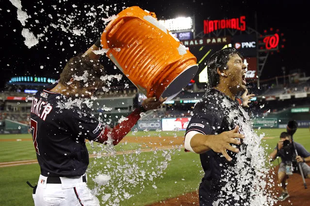 Washington Nationals' Kurt Suzuki, right, is doused by Trea Turner after hitting a game-winning three-run home run in the ninth inning of the team's baseball game against the New York Mets, Tuesday, September 3, 2019, in Washington. Washington won 11-10. (Photo by Patrick Semansky/AP Photo)