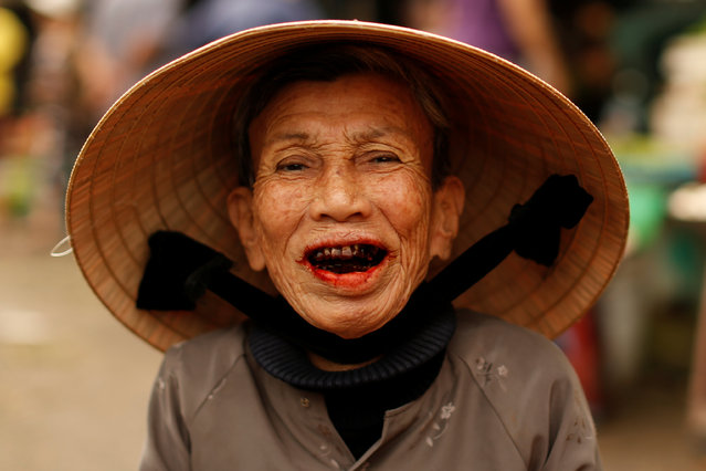 A woman wearing a traditional hat, known as a non la, poses for a portrait at a market in Hoi An, Vietnam April 5, 2016. (Photo by Jorge Silva/Reuters)