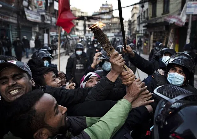 Youth activists of the Communist Party of Nepal (Unified Socialist) scuffle with police during a protest against the government's decision to increase prices of petrol, diesel and kerosene, currently at an all-time high, in Kathmandu, Nepal, 05 February 2022. (Photo by Narendra Shrestha/EPA/EFE)