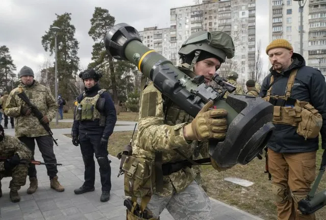 A Ukrainian Territorial Defence Forces member holds an NLAW anti-tank weapon, in the outskirts of Kyiv, Ukraine, Wednesday, March 9, 2022. Authorities announced a new ceasefire on Wednesday to allow civilians to escape from towns around the capital, Kyiv, as well as the southern cities of Mariupol, Enerhodar and Volnovakha, Izyum in the east and Sumy in the northeast. Previous attempts to establish safe evacuation corridors have largely failed due to attacks by Russian forces. (Photo by Efrem Lukatsky/AP Photo)