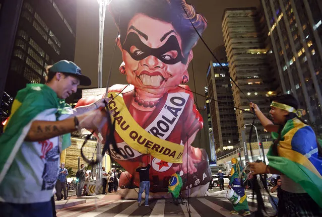 Anti-government demonstrators set up a large inflatable doll in the likeness of Brazil's President Dilma Rousseff wearing a presidential sash with the words in Portuguese “Goodbye dear” and “Mother of Big Oil” written on it, in Sao Paulo, Brazil, Wednesday, May 11, 2016. Brazilian President Dilma Rousseff is facing possible impeachment by Congress, with the Senate expected to vote on a measure to suspend her from office. (Photo by Andre Penner/AP Photo)