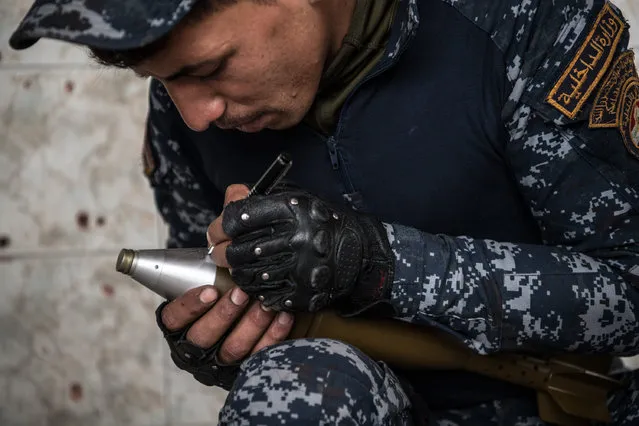 An Iraqi federal policeman writes a Shia religious blessing on a mortar before firing it at an Islamic State position in west Mosul, on April 12, 2017 in Mosul, Iraq. Despite being completely surrounded, Islamic State fighters are continuing to put up stiff resistance to Iraqi forces who are now having to engage I.S in house to house fighting as they continue their battle to retake Iraq's second largest city of Mosul. (Photo by Carl Court/Getty Images)
