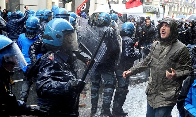 Protesters clash with riot police as they attempt to force their way closer to a Labor Day march, in Turin, Italy, Monday, May 1, 2017. (Photo by Alessandro Di Marco/ANSA via AP Photo)