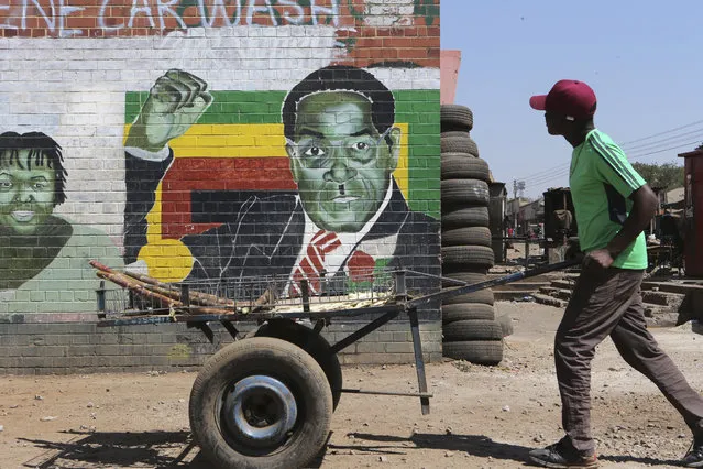 A man pushes an empty cart past a portrait of former Zimbabwean President Robert Mugabe in Harare, Friday, September 6, 2019. Robert Mugabe, the former leader of Zimbabwe forced to resign in 2017 after a 37-year rule whose early promise was eroded by economic turmoil, disputed elections and human rights violations, has died. He was 95. (Photo by Tsvangirayi Mukwazhi/AP Photo)