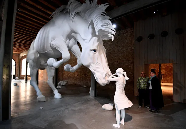 Visitors admire the art work “The horse problem” by Argentinian artist Claudia Fontes  during the press preview of the 57th International Art Exhibition Biennale, on May 9, 2017 in Venice. The exhibition, titled “Viva Arte Viva” is curated by Christine Macel and will be open to the public from May 13 to November 26, 2017 at the Giardini and Arsenale venues. (Photo by Vincenzo Pinto/AFP Photo)