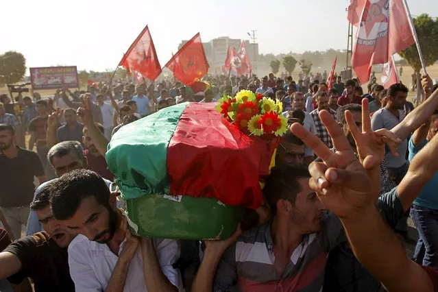 Relatives and friends carry the coffin of a victim who was killed in Monday's bomb attack, during a funeral ceremony at a cemetery in Suruc, Turkey, July 21, 2015. (Photo by Reuters/Stringer)