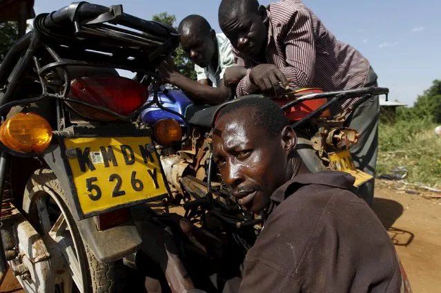 Ernest Ogoe, a 43-year-old motorbike mechanic, works at his garage in the trading centre of Kogelo, west of Kenya's capital Nairobi, July 15, 2015. Ogoe said, “We want Barack Obama to come home more after he vacates the U.S. Presidential seat in 2017”. “Our children need better education therefore we want more schools”, he added. (Photo by Thomas Mukoya/Reuters)