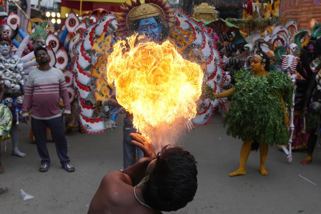 An artist performs a fire stunt during a procession marking “Bonalu” festival in Hyderabad, India, Monday, July 29, 2024. Bonalu is a month-long Hindu folk festival dedicated to Kali, the Hindu goddess of destruction. (Photo by Mahesh Kumar A./AP Photo)