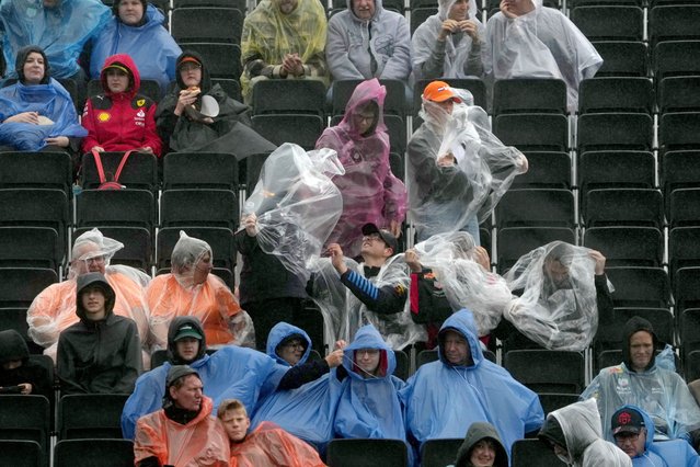 Fans cover up as rain falls prior to the first practice session ahead of the Formula One Dutch Grand Prix auto race, at the Zandvoort racetrack, Netherlands, Friday, August 23, 2024. (Photo by Peter Dejong/AP Photo)