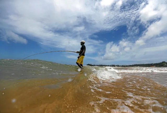 A man holds his fishing rod as he waits to catch fish on the beach in Galle, Sri Lanka May 29, 2016. (Photo by Dinuka Liyanawatte/Reuters)