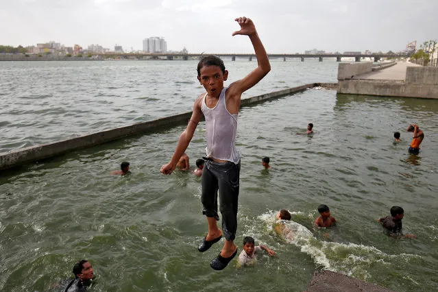 A boy reacts as he jumps into the Sabarmati river to cool off on a hot summer day in Ahmedabad, India June 6, 2017. (Photo by Amit Dave/Reuters)