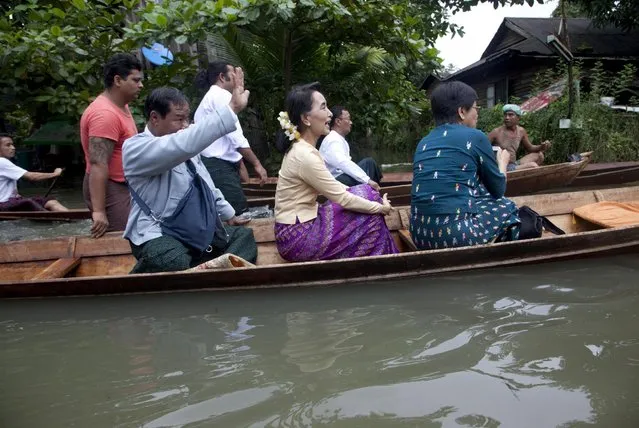 Myanmar opposition leader Aung San Suu Kyi, center, rides a boat on her way to a monastery where flood victims are sheltered, Monday, August 3, 2015, in Bago, 80 kilometers (50 miles) northeast of Yangon, Myanmar. (Photo by hin Maung Win/AP Photo/)