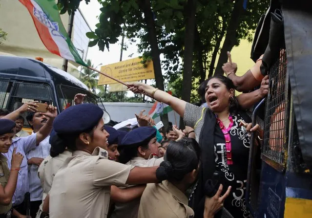 An activist of India's opposition Congress party shouts slogans as she is detained by police during a protest in Mumbai, India, Wednesday, August 5, 2015. The opposition has been demanding that two leaders of the ruling Bharatiya Janata Party (BJP) resign for allegedly helping a former Indian cricket official facing investigation for financial irregularities. (Photo by Rafiq Maqbool/AP Photo)