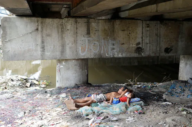 A man and a child sleep under a bridge in Paranaque city, Metro Manila, Philippines May 31, 2016. (Photo by Ezra Acayan/Reuters)