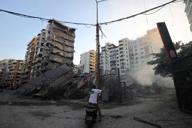 A man photographs the rubble of a building levelled by an Israeli airstrike that targeted Beirut's southern suburbs, on October 5, 2024. Israel's military launched an intensified wave of strikes on Hezbollah strongholds around Lebanon, killing more than 1,110 people since September 23, and forcing hundreds of thousands to flee their homes in a country already mired in economic crisis. (Photo by Anwar Amro/AFP Photo)