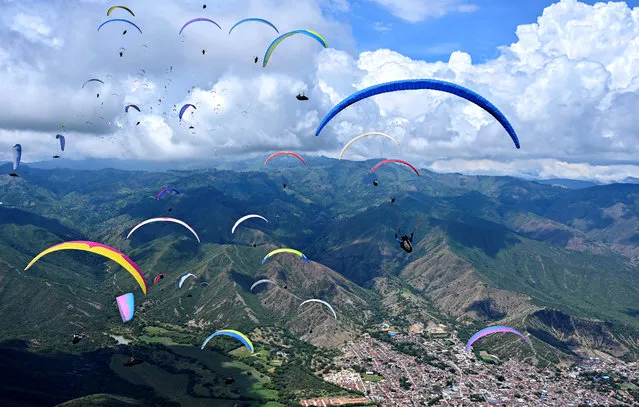 Paraglider pilots fly over the mountains in Roldanillo, Valle del Cauca Department, Colombia, during the British Winter Open, on January 25, 2020. The competition is taking place for the second time in Colombia and involves the 130 world's best pilots from 27 countries. (Photo by Luis Robayo/AFP Photo)