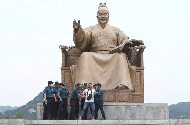 South Korean policemen detain a nonregular worker of Kia Motors Corp., South Korea's No. 2 carmaker by sales, as they try to occupy a statue of King Sejong at Gwanghwamun Plaza in Seoul, South Korea, 27 July 2017. Protesters called for the arrest of the carmaker's chief, Chung Mong-koo. (Photo by Yang Ji-Woong/EPA)