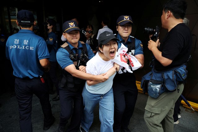 A university student is detained while attempting to break into the Japanese embassy on the occasion of Japan releasing treated radioactive water from the wrecked Fukushima nuclear power plant into the Pacific Ocean, in Seoul, South Korea on August 24, 2023. (Photo by Kim Hong-Ji/Reuters)