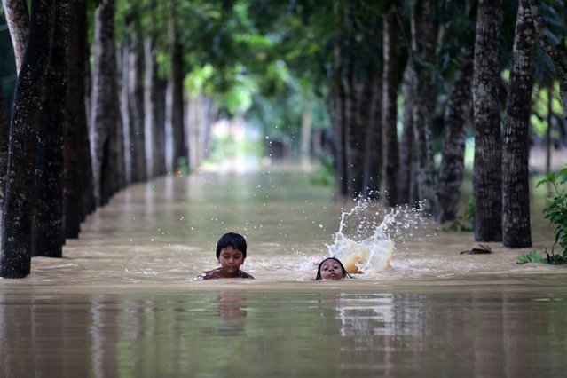 Two children swim on the flood water after a widespread flash flood at Nalitabari sub district in Sherpur district, Bangladesh, 08 October 2024. According to Bangladesh Water Development Board (BWDB) officials, at least 50,000 people remain stranded in five sub districts in Sherpur despite flood conditions improving. (Photo by EPA/EFE/Stringer)