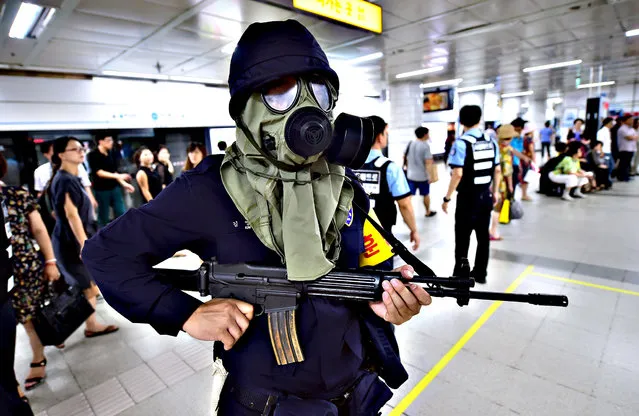 A South Korean armed policeman wears a gas mask during an anti-terror drill on the sidelines of South Korea-US joint military exercise, called Ulchi Freedom Guardian, at a subway station in Seoul on August 19, 2015. Tens of thousands of South Korean and US troops on August 17 began a military exercise simulating an all-out North Korean attack, as Pyongyang matched Seoul in resuming a loudspeaker propaganda campaign across their heavily-fortified border. (Photo by Jung Yeon-Je/AFP Photo)