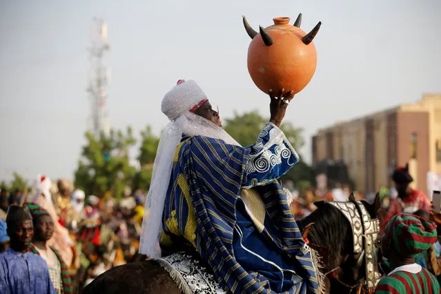 A traditional chief rides a horse while holding a calabash during the durbar festival on the second day of Eid-al-Fitr celebrations in Nigeria's northern city of Kano, July 7, 2016. (Photo by Akintunde Akinleye/Reuters)
