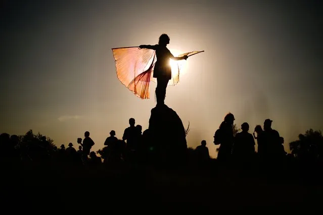 A festival attendee is silhouetted as they stand atop of the stone circle during the Glastonbury Festival at Worthy Farm in Somerset on Wednesday, June 22, 2022. (Photo by Ben Birchall/PA Images via Getty Images)