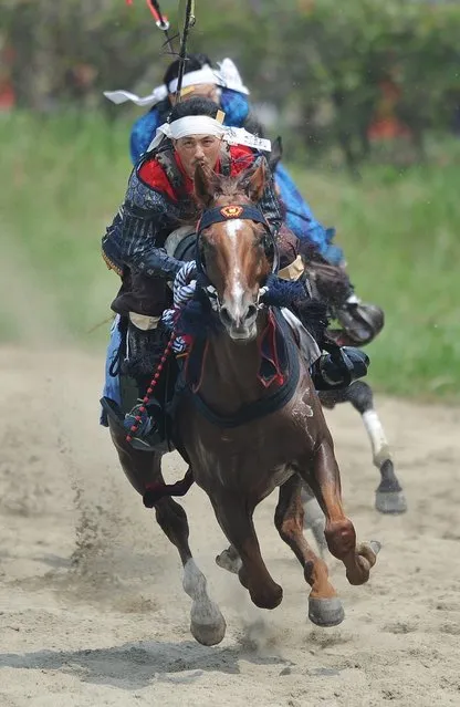 Local people in samurai armor race horses during the annual Soma Nomaoi Festival in Minamisoma, Fukushima Prefecture, on July 29, 2012. Some 400 horses and thousands of people took part in the 1,000-year-old “Soma Nomaoi”, or wild horse chase, at the weekend in the shadow of Japan's crippled Fukushima nuclear plant. (Photo by Toru Yamanaka/AFP Photo)