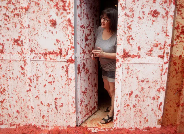 A resident peers out of her door during the annual Tomatina festival in Bunol near Valencia, Spain on August 30, 2017. (Photo by Heino Kalis/Reuters)