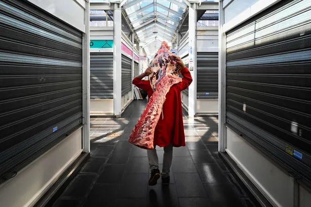 A delivery man transports meat past closed stalls to the butcher's shop at a market in Rome on March 12, 2020, as Italy shut all stores except for pharmacies and food shops in a desperate bid to halt the spread of a coronavirus that has killed 827 in the the country in just over two weeks. (Photo by Alberto Pizzoli/AFP Photo)