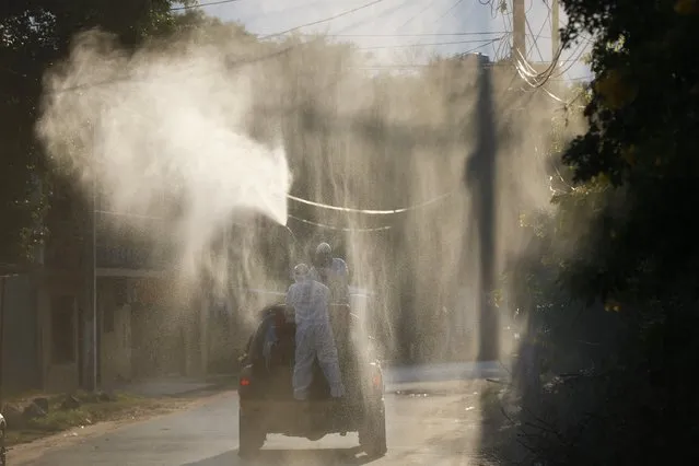 Voluntary firefighters take part in a fumigation initiative as a precaution against the spread of the new coronavirus, on the outskirts of Asuncion, Paraguay, Saturday, March 28, 2020. (Photo by Jorge Saenz/AP Photo)
