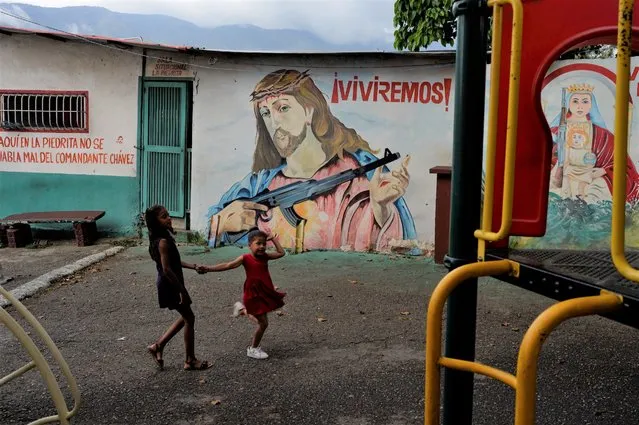 A mural mixing revolutionary and religious iconography covers a wall in the 23 de Enero neighborhood of Caracas, Venezuela, Thursday, July 28, 2022. (Photo by Ariana Cubillos/AP Photo)