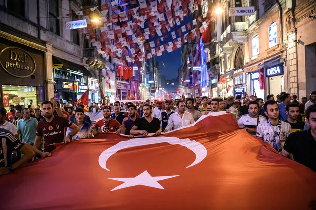 Turkish football supporters take part in a rally against the military coup on Taksim square in Istanbul on July 23, 2016. Turkey pushed on with a sweeping crackdown against suspected plotters of its failed coup, defiantly telling EU critics it had no choice but to root out hidden enemies. Using new emergency powers, President Recep Tayyip Erdogan's cabinet decreed that police could now hold suspects for one month without charge, and also announced it would shut down over 1,000 private schools it deems subversive. (Photo by Ozan Kose/AFP Photo)