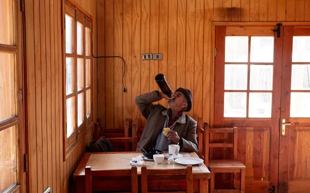 A man chugs a bottles of black beer while eating breakfast at a restaurant in Paine, Chile, Friday, August 23, 2019. (Photo by Esteban Felix/AP Photo)