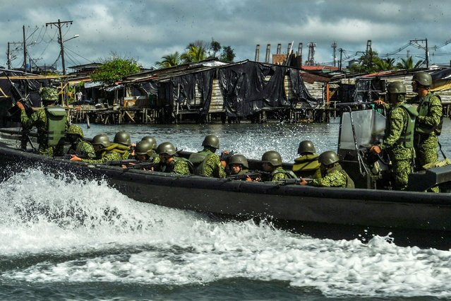 Members of the Colombian Navy patrol on a boat in Buenaventura, Colombia, on Septemebr 3, 2022. Most of Buenaventura is controled by local gangs that dispute the territory with violence and illegal economies like drug trafficking and extorsion. (Photo by Joaquin Sarmiento/AFP Photo)